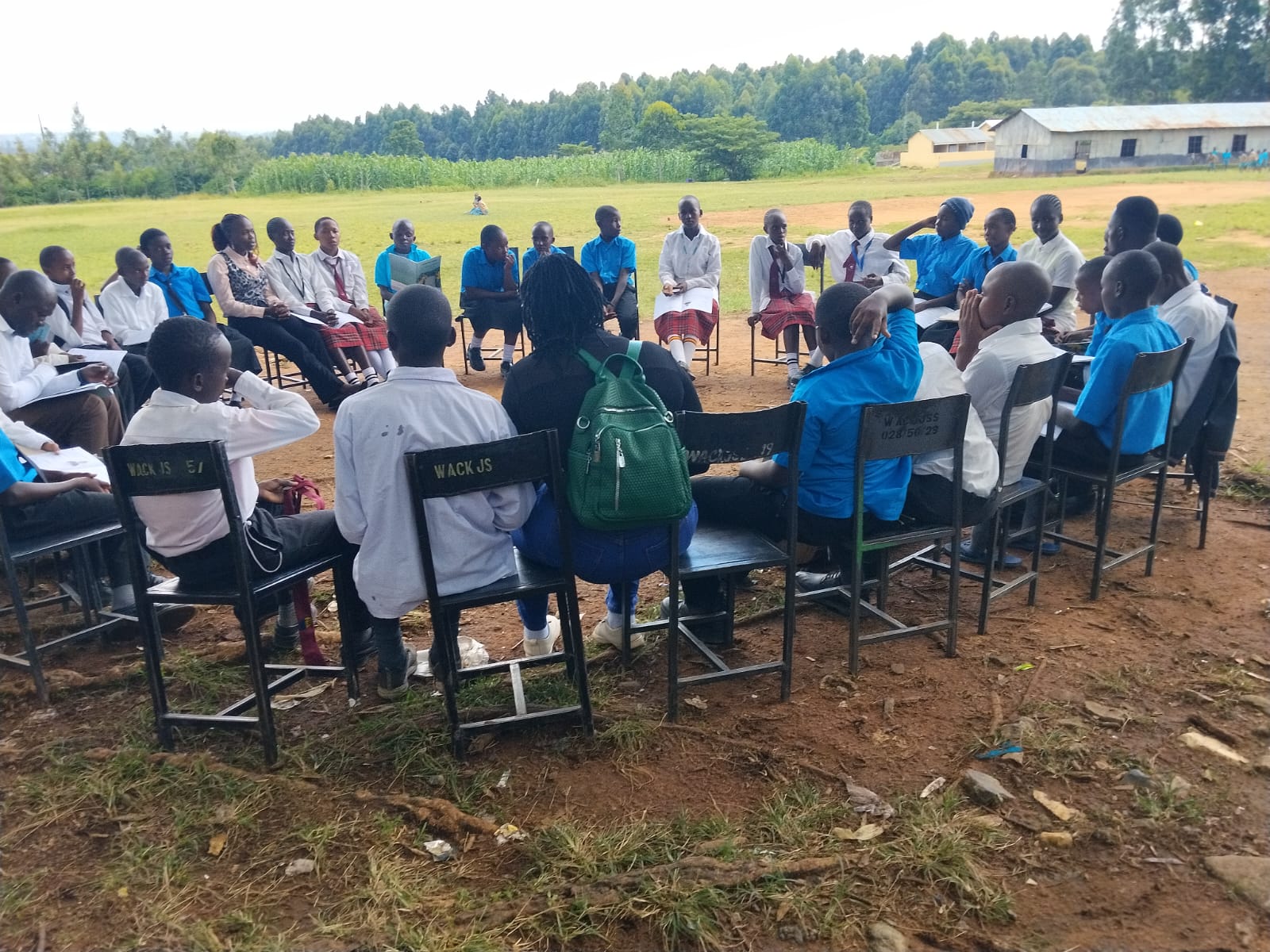 Young people studying with a mentor in a sunlit classroom in western Kenya