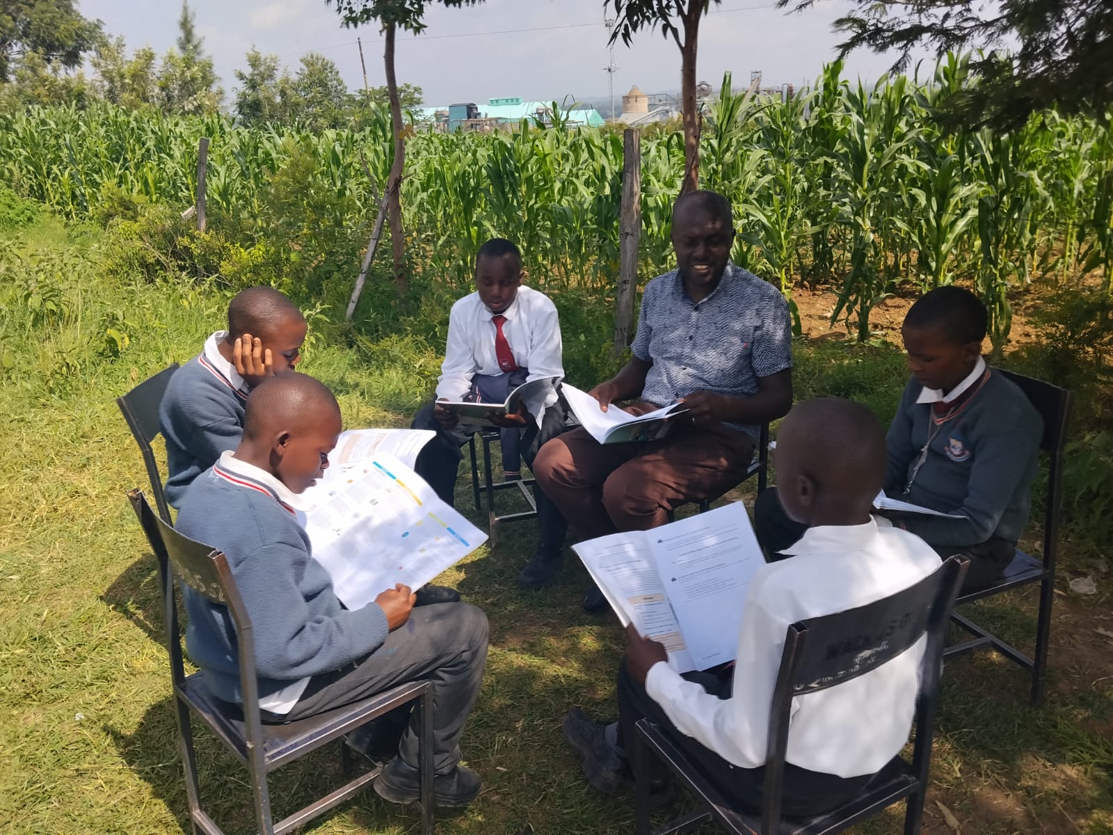 A youth mentorship circle seated under a tree in the western Kenya highlands